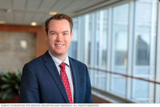 Un cirujano de Oncología Ortopédica de Mayo Clinic sonríe en señal de saludo.